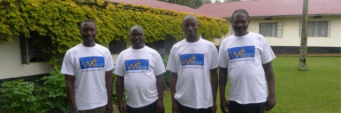 Four members of staff in Uganda wearing WATSAN t-shirts
